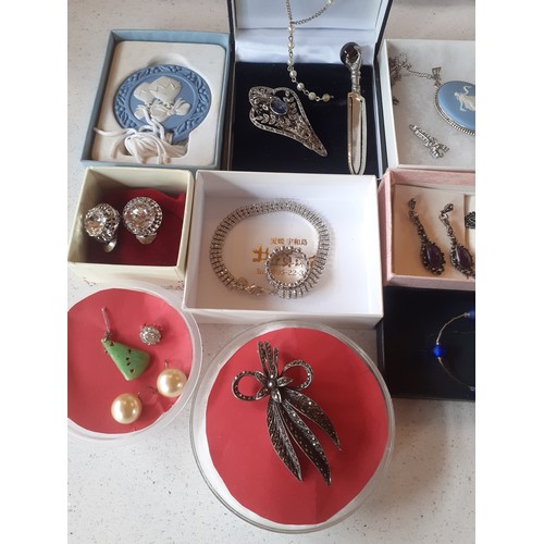 75 - A quantity of costume jewellery to include a Wedgwood blue Jasperware pendant on silver tone chain a... 