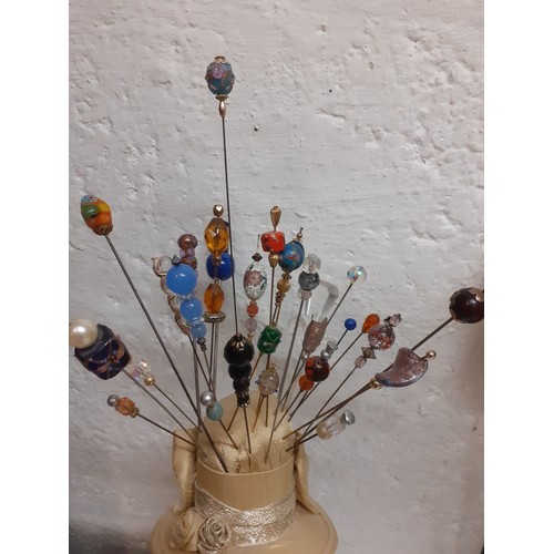 106 - A collection of decorative hat pins to include early 20th Century glass bead examples, a millie fleu... 