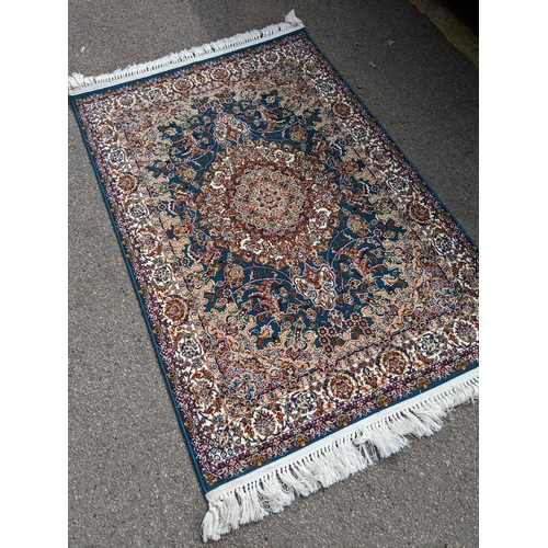 423 - A modern machine woven Persian style rug, ornate design on a dark turquoise ground, triple guard bor... 