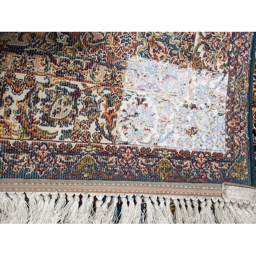 423 - A modern machine woven Persian style rug, ornate design on a dark turquoise ground, triple guard bor... 