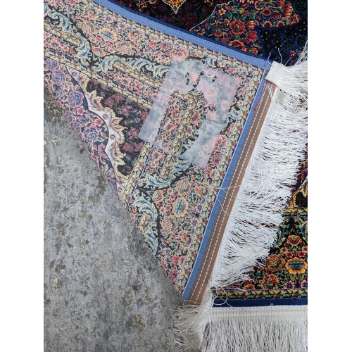 426 - A contemporary small Persian style, machine woven rug, floral design surrounded by a central floral ... 