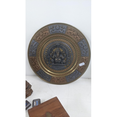 114 - A mixed lot to include a brass and copper Hindu wall hanging plaque, together with an Indonesian tre... 