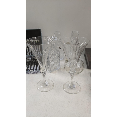 186 - Glassware to include a pair of crystal cut stem champagne flutes, three crystal cut decanters, and a... 