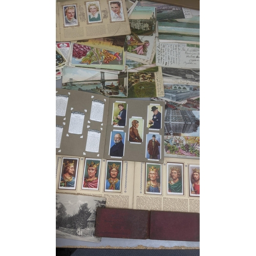 223 - A mixed lot to include cigarette card albums and loose examples, together with a collection of postc... 