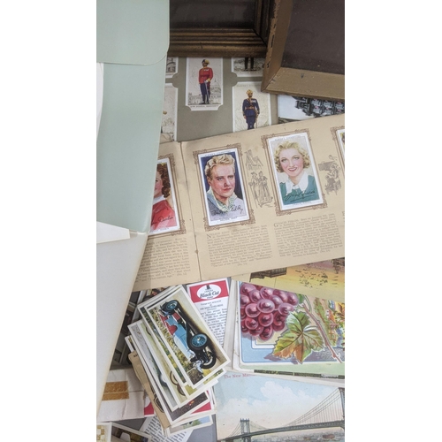 223 - A mixed lot to include cigarette card albums and loose examples, together with a collection of postc... 