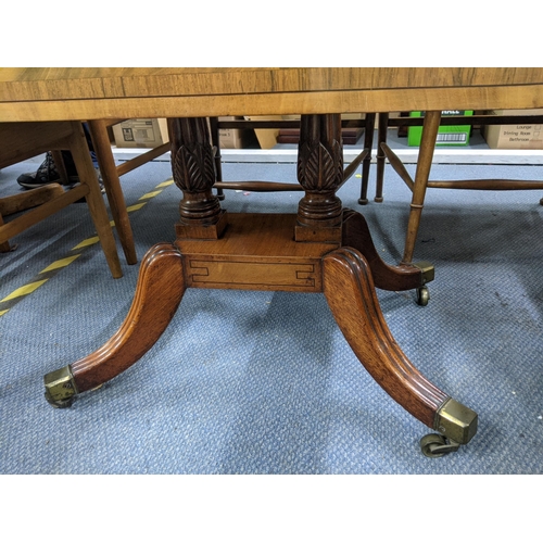 326 - A late 19th/early 20th century flame mahogany Pembroke table raised on two decorative supports on a ... 