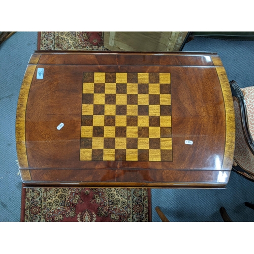 328 - A flame mahogany dropleaf gaming table with a chessboard design on top, a pair of faux drawers with ... 