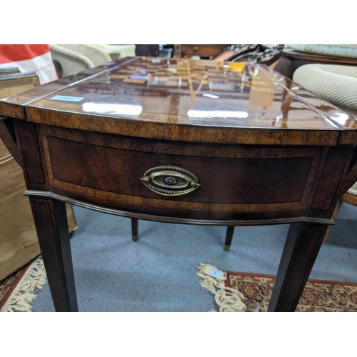 328 - A flame mahogany dropleaf gaming table with a chessboard design on top, a pair of faux drawers with ... 