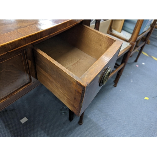 331 - An early 20th century mahogany three-drawer desk with ring handles raised on tapered legs Location: ... 