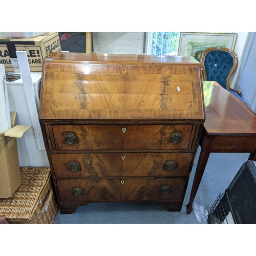 336 - A George III flame mahogany bureau with satinwood and ebony inlay with a fall flap, three drawers, r... 