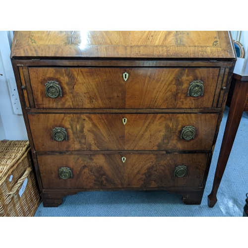 336 - A George III flame mahogany bureau with satinwood and ebony inlay with a fall flap, three drawers, r... 