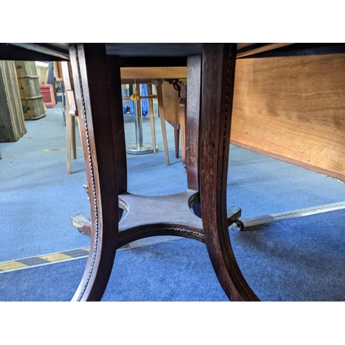 343 - A mid Victorian rosewood circular dining table with splayed legs and a fitted shelf underneath, on c... 