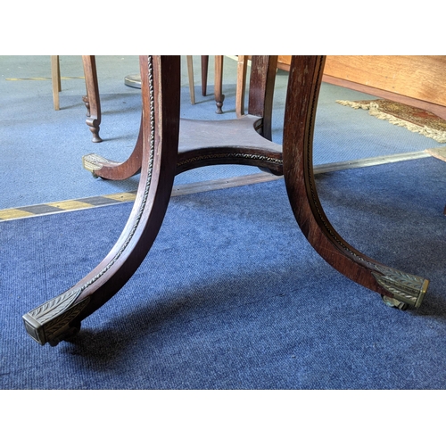 343 - A mid Victorian rosewood circular dining table with splayed legs and a fitted shelf underneath, on c... 