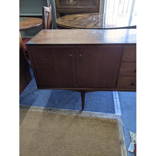 345 - An Everest teak sideboard with cupboards at both ends and three central drawers, raised on turned le... 