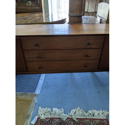 345 - An Everest teak sideboard with cupboards at both ends and three central drawers, raised on turned le... 