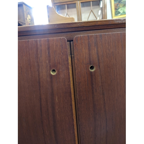 345 - An Everest teak sideboard with cupboards at both ends and three central drawers, raised on turned le... 