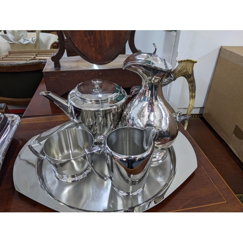 346 - A stainless steel tea set comprising a teapot, milk jug, sugar bowl, along with a silver plated wate... 