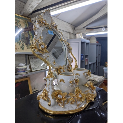 347 - A modern bathroom swivel ceramic mirror decorated with flowers and gilding with two pots in front of... 