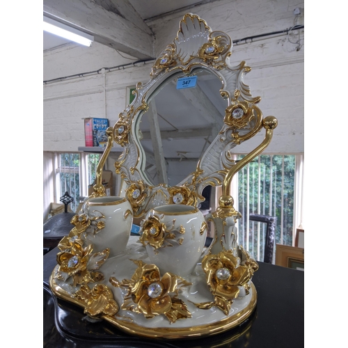 347 - A modern bathroom swivel ceramic mirror decorated with flowers and gilding with two pots in front of... 