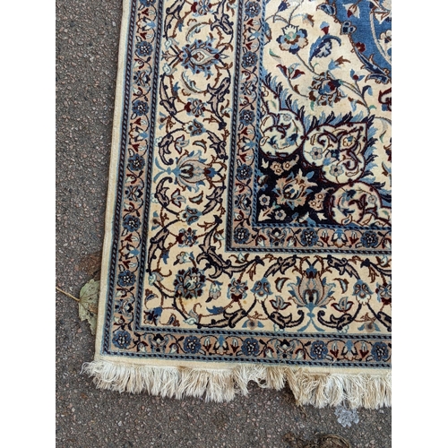 349 - A Persian hand knotted rug with a cream border with repeating motifs and a symmetrical star and surr... 