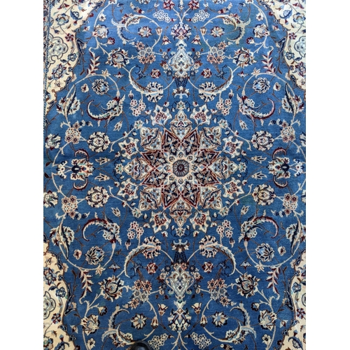 349 - A Persian hand knotted rug with a cream border with repeating motifs and a symmetrical star and surr... 