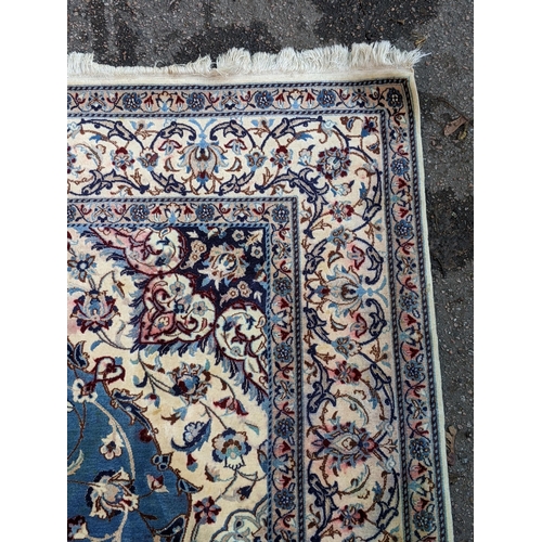 349 - A Persian hand knotted rug with a cream border with repeating motifs and a symmetrical star and surr... 