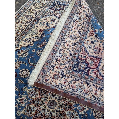 349 - A Persian hand knotted rug with a cream border with repeating motifs and a symmetrical star and surr... 