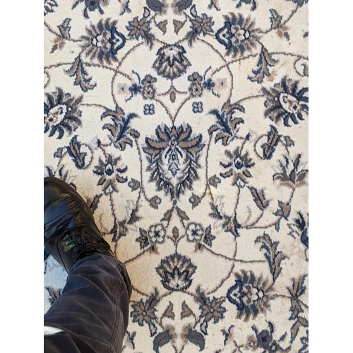 351 - A modern machine made rug with abstract floral decoration, repeating blue border on a cream backgrou... 