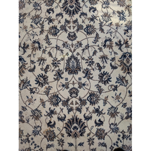 351 - A modern machine made rug with abstract floral decoration, repeating blue border on a cream backgrou... 