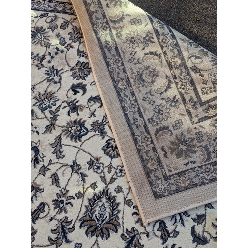 351 - A modern machine made rug with abstract floral decoration, repeating blue border on a cream backgrou... 