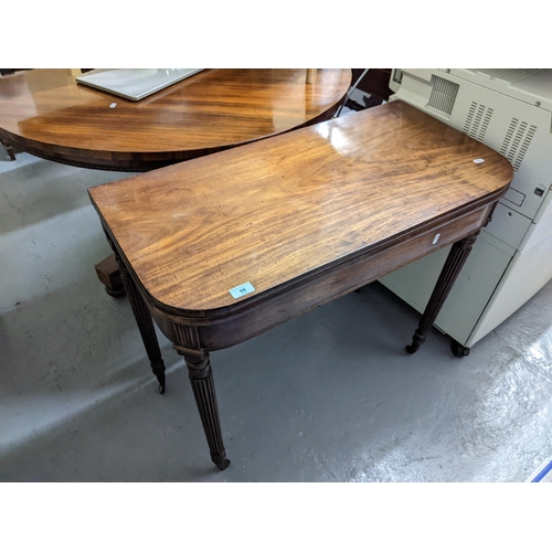 66 - A Victorian mahogany fold over and swivel topped card table, on turned, tapering and fluted legs, 73... 