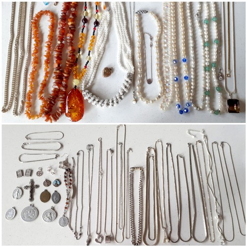 125 - A quantity of costume jewellery to include a rough cut amber necklace, a modern amber necklace A/F, ... 