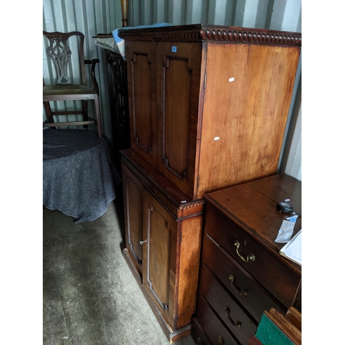 514 - A 19th century mahogany cabinet with a gadrooned cornice over four panelled doors, each enclosing sh... 