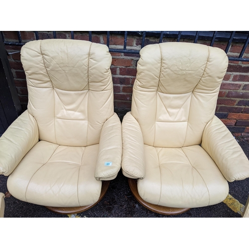 524 - A pair of Stressless cream/yellow leather upholstered reclining armchairs with matching stools Locat... 