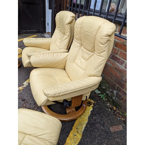 524 - A pair of Stressless cream/yellow leather upholstered reclining armchairs with matching stools Locat... 