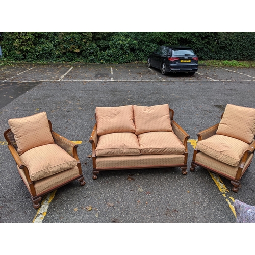 532 - A 1920's walnut framed bergère three piece suite with shot silk style fabric on ball and claw feet
L... 