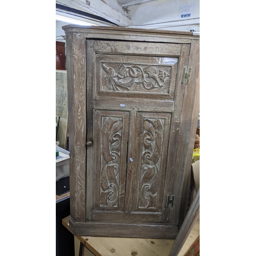 481 - An early 19th century limed oak corner cabinet having a single door fitted with shelves, 130.5cm h x... 