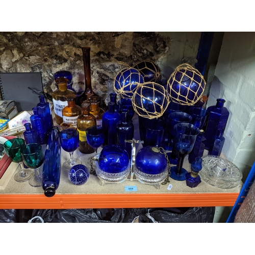 444 - A collection of glassware, mainly blue glass, and amber coloured chemist bottles to include a blue g... 