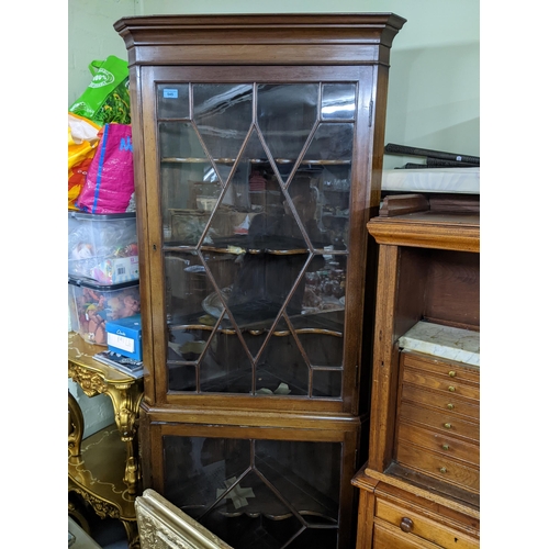 545 - A mahogany two-section corner cabinet, two astragal glazed display doors and shaped internal shelves... 