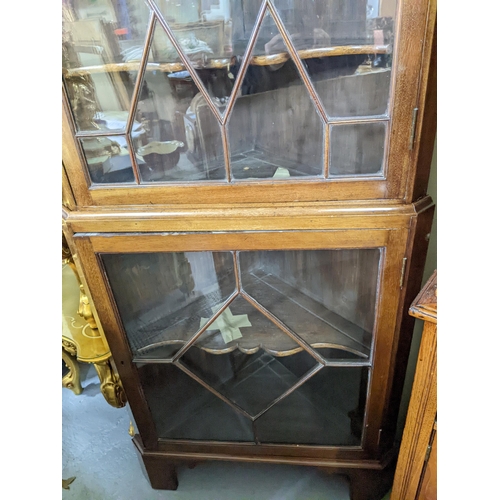 545 - A mahogany two-section corner cabinet, two astragal glazed display doors and shaped internal shelves... 