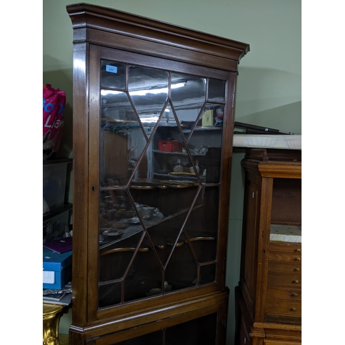 545 - A mahogany two-section corner cabinet, two astragal glazed display doors and shaped internal shelves... 