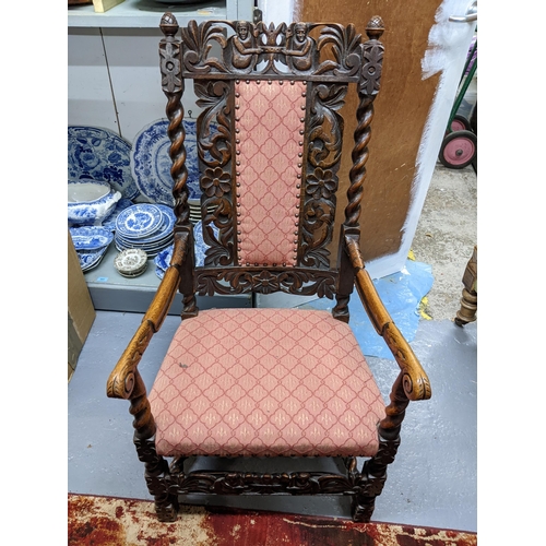 547 - A Carolean style oak carved armchair with pineapple finials, barley twist column supports, upholster... 