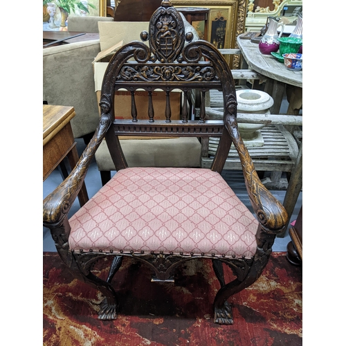 548 - A late 19th/early 20th century carved oak armchair, scrolled and break top crest rail with carved co... 