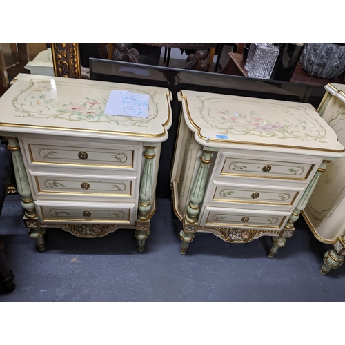 556 - A matching pair of bedside chests of three drawers, cream painted with floral decoration, the drawer... 