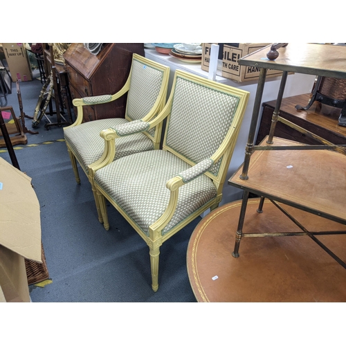 469 - A pair of pale yellow painted French style armchairs upholstered in floral fabric raised on tapering... 