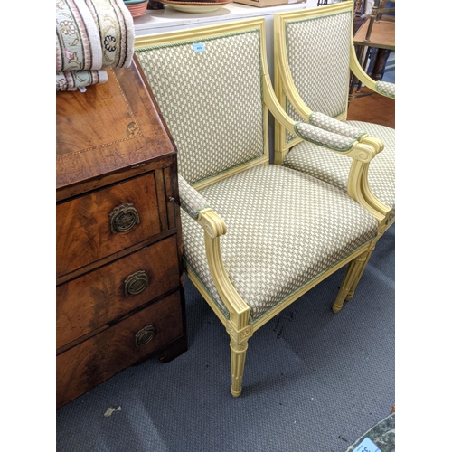 469 - A pair of pale yellow painted French style armchairs upholstered in floral fabric raised on tapering... 