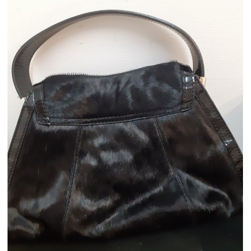 12 - Karen Millen-A black pony skin effect and patent handbag with silver tone hardware, an interior zipp... 