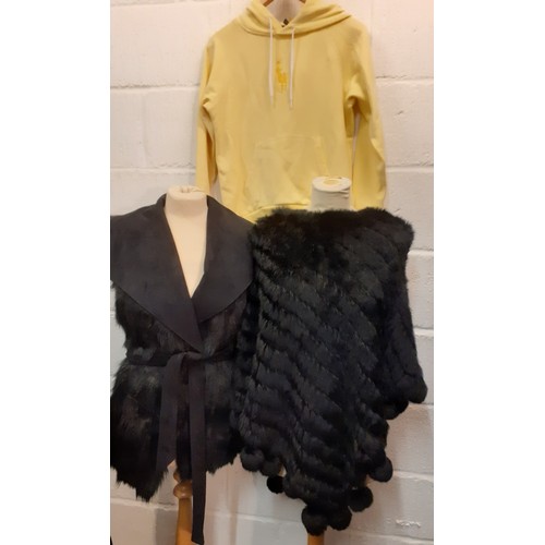 127 - A group of modern clothing to include a black rabbit fur poncho with racoon pom pom trim, one size, ... 