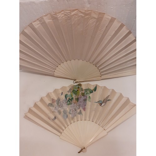 162 - Two Victorian bone and cream silk fans, one hand-painted with a bird in-flight approaching a blossom... 