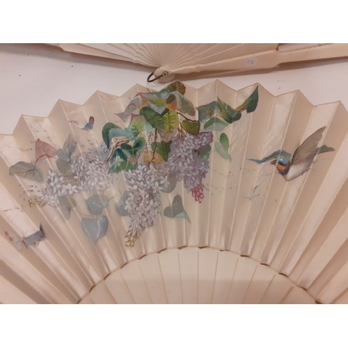 162 - Two Victorian bone and cream silk fans, one hand-painted with a bird in-flight approaching a blossom... 